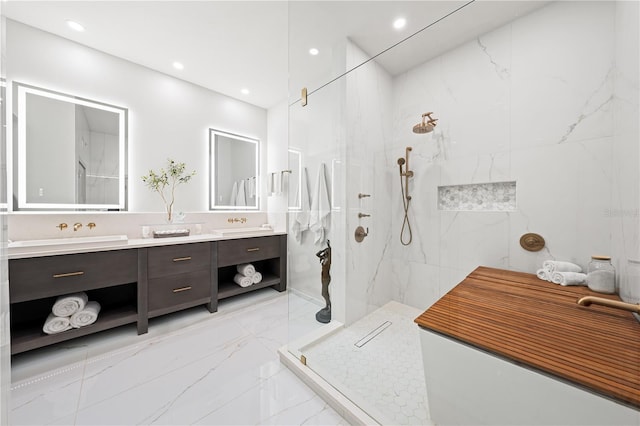 bathroom with a tile shower, vanity, and tile walls