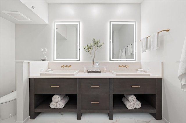 full bathroom with visible vents, a sink, toilet, and double vanity