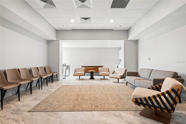 living room with visible vents and a drop ceiling