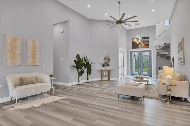 living area featuring a high ceiling, light hardwood / wood-style floors, and french doors