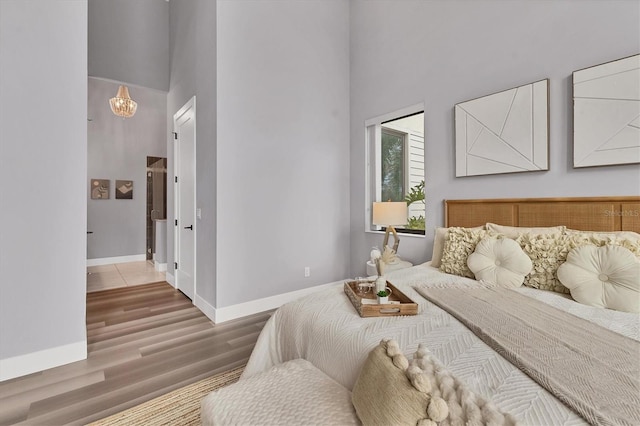 bedroom with hardwood / wood-style flooring and a high ceiling