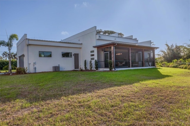 back of house featuring a sunroom, cooling unit, and a lawn