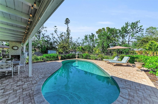 7820 Seville Cir, Bradenton, FL 34209 - view of swimming pool with a patio, an outdoor brick fireplace, and a fenced backyard