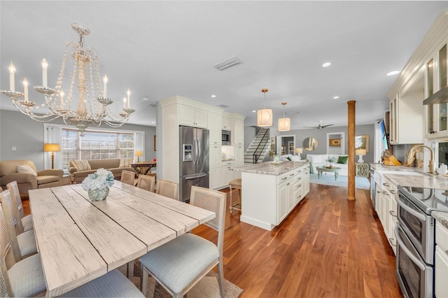 7820 Seville Cir, Bradenton, FL 34209 - dining space featuring stairs, ceiling fan, a chandelier, dark wood-style flooring, and recessed lighting