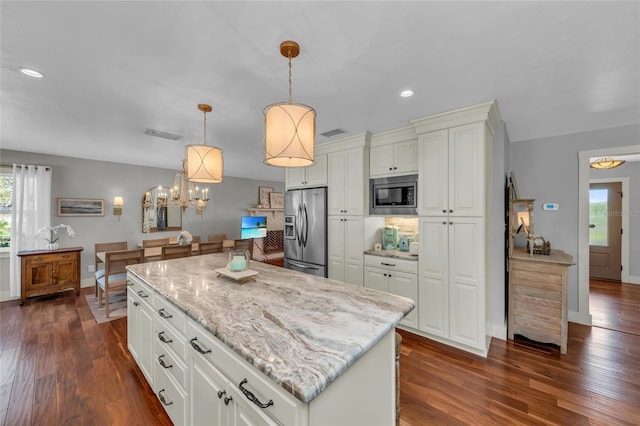 7820 Seville Cir, Bradenton, FL 34209 - kitchen featuring stainless steel appliances, dark wood finished floors, light stone countertops, recessed lighting, and decorative light fixtures