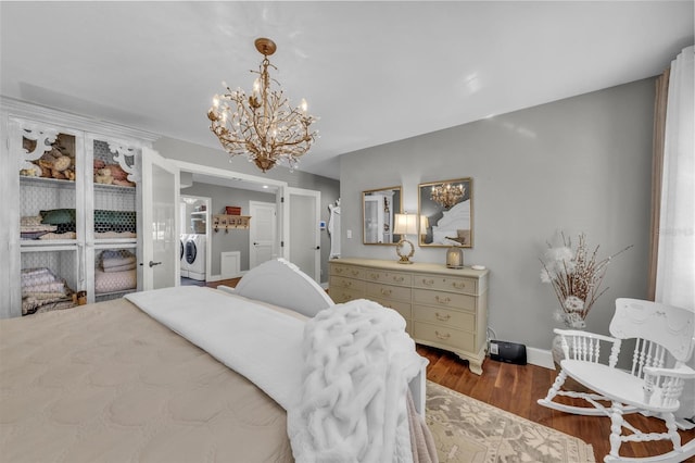 7820 Seville Cir, Bradenton, FL 34209 - bedroom featuring a chandelier, dark wood-type flooring, baseboards, and washer and dryer