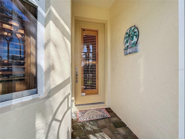 view of exterior entry with stucco siding