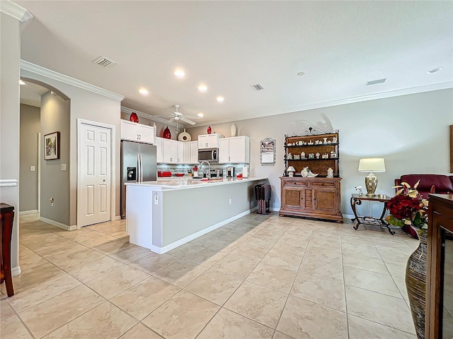 kitchen featuring arched walkways, visible vents, stainless steel appliances, and light countertops