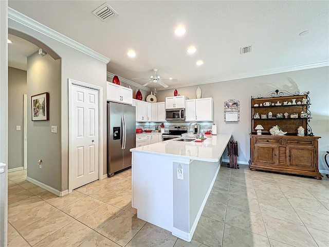 kitchen featuring visible vents, a peninsula, arched walkways, ornamental molding, and appliances with stainless steel finishes