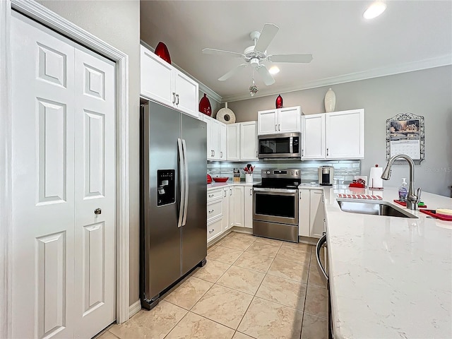 kitchen featuring backsplash, stainless steel appliances, light tile patterned flooring, white cabinetry, and a sink