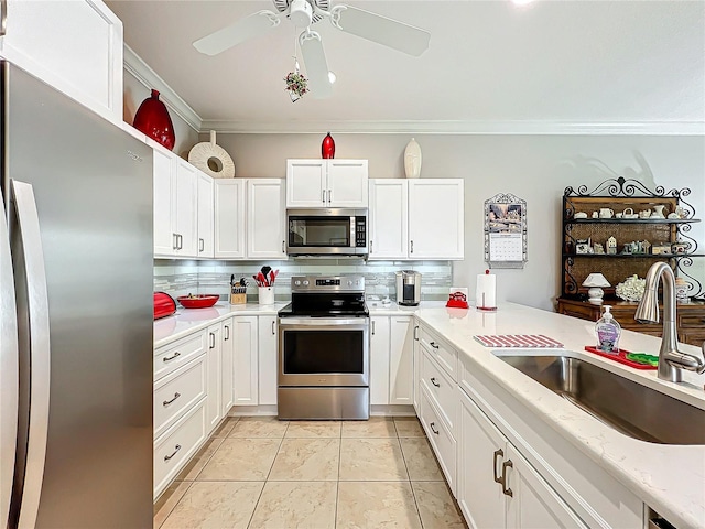 kitchen with a sink, white cabinets, appliances with stainless steel finishes, crown molding, and tasteful backsplash