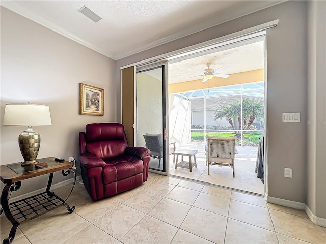 sitting room featuring crown molding, baseboards, light tile patterned flooring, a textured ceiling, and a ceiling fan