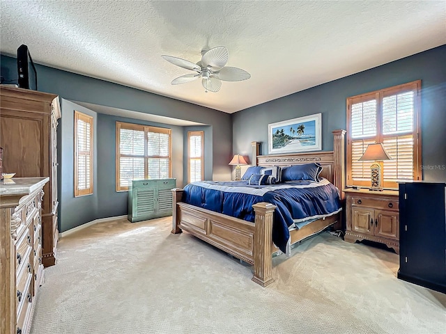 bedroom with light carpet, multiple windows, and a textured ceiling