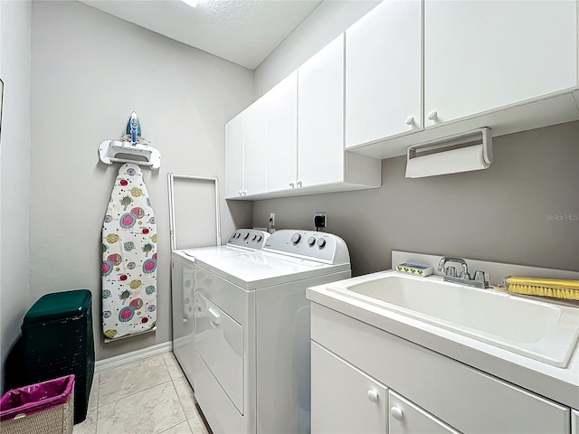 clothes washing area with cabinet space, independent washer and dryer, and a sink