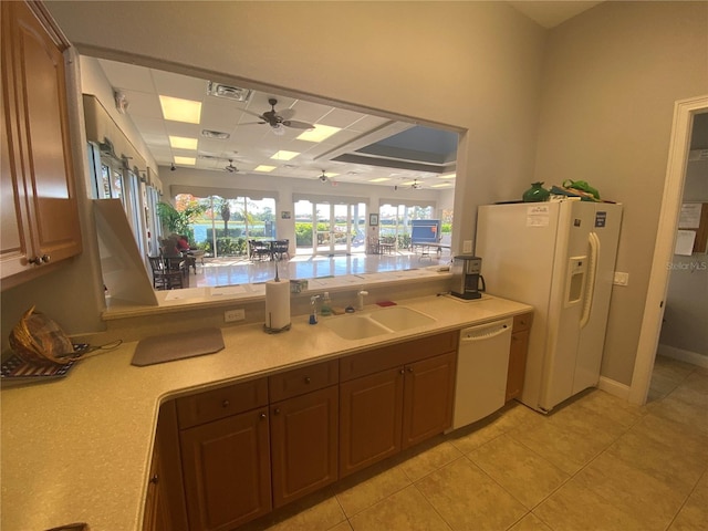 kitchen featuring visible vents, light countertops, light tile patterned floors, white appliances, and a sink