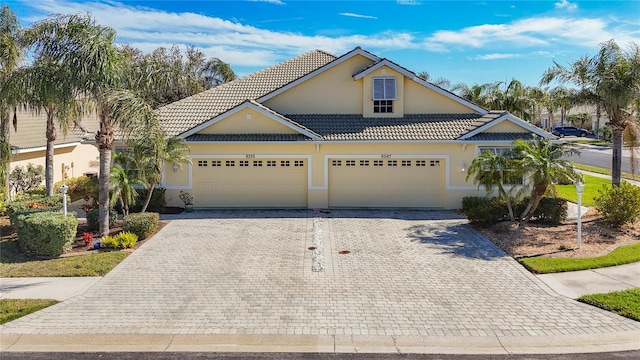 view of front of home featuring decorative driveway, stucco siding, and a tiled roof