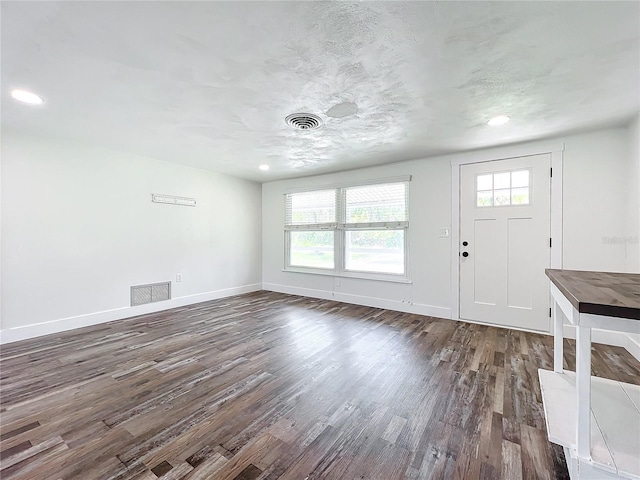 foyer entrance featuring dark wood-type flooring and a textured ceiling