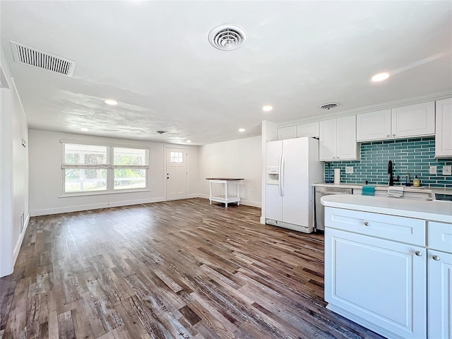 kitchen with dishwasher, white cabinetry, wood-type flooring, white refrigerator with ice dispenser, and decorative backsplash