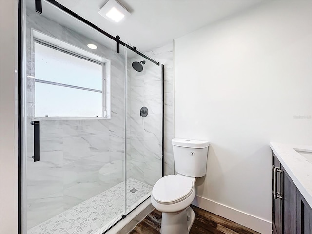 bathroom with an enclosed shower, vanity, hardwood / wood-style flooring, and toilet