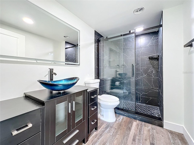 bathroom with vanity, hardwood / wood-style flooring, toilet, and walk in shower