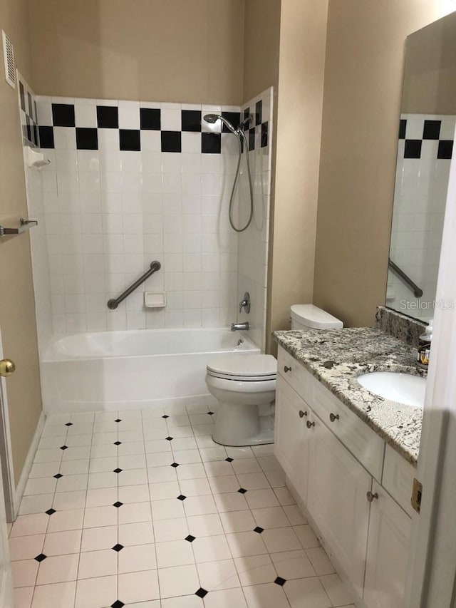 full bathroom with tile patterned flooring, vanity, toilet, and tiled shower / bath