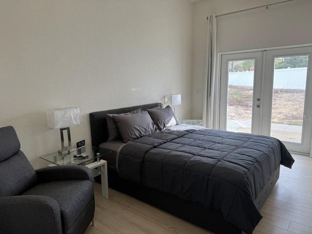 bedroom featuring french doors, access to exterior, and light hardwood / wood-style flooring