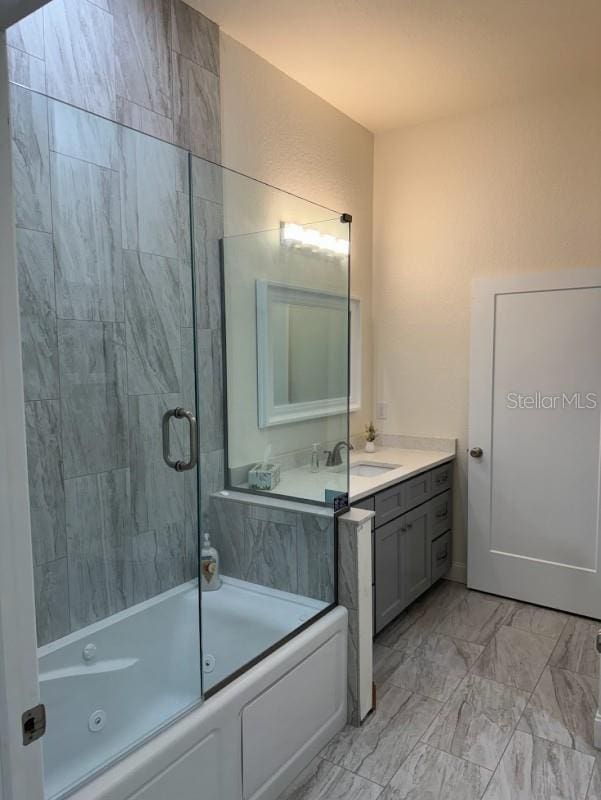 bathroom featuring vanity and shower / bath combination with glass door