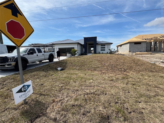 view of front of property featuring a garage and a front lawn