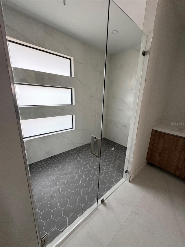 bathroom with tile patterned flooring, vanity, and a shower with shower door