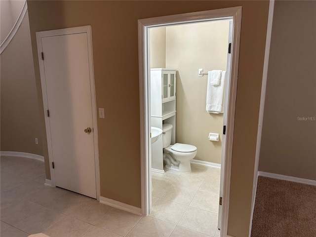 bathroom featuring tile patterned floors, baseboards, and toilet