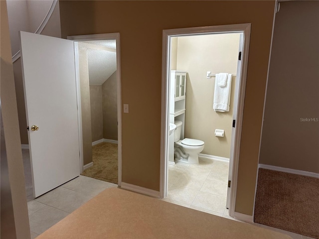 bathroom featuring tile patterned flooring, toilet, and baseboards