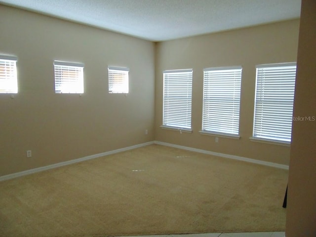 unfurnished room featuring carpet floors and baseboards