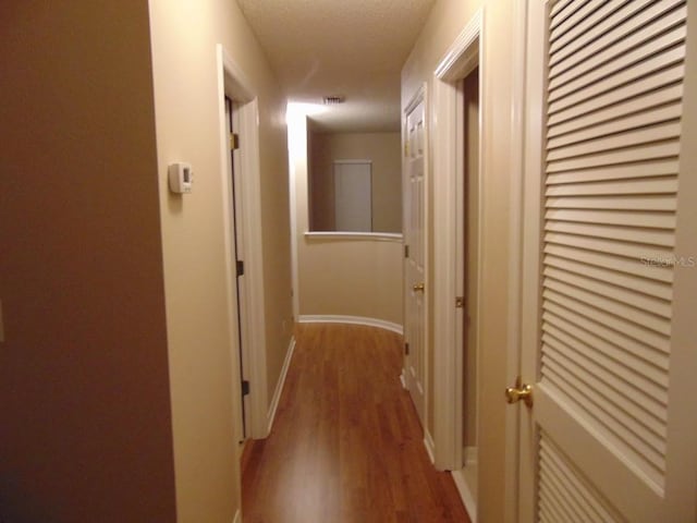 corridor with light wood finished floors and baseboards