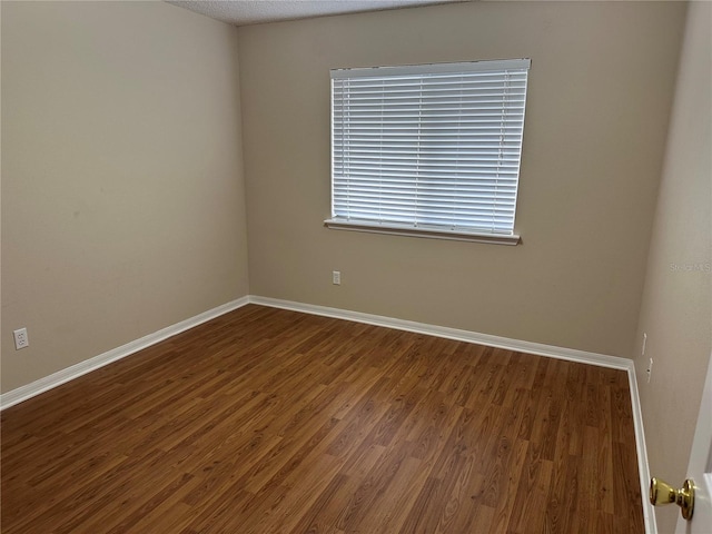 unfurnished room featuring wood finished floors and baseboards