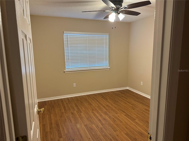 empty room with wood finished floors, ceiling fan, baseboards, and a textured ceiling