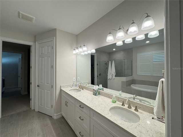 bathroom featuring vanity, shower with separate bathtub, and hardwood / wood-style floors