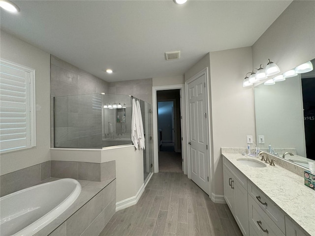 bathroom with vanity and independent shower and bath