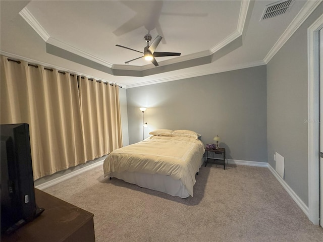 carpeted bedroom with crown molding, ceiling fan, and a raised ceiling