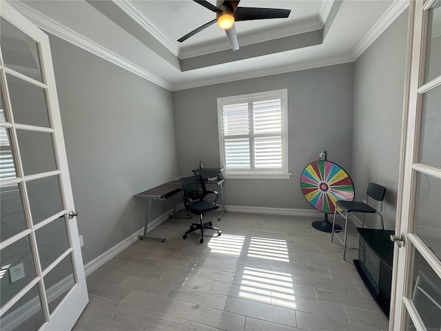 unfurnished office featuring ornamental molding, a raised ceiling, and ceiling fan