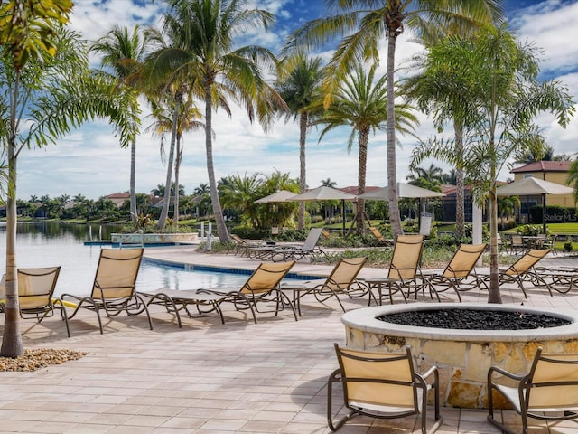 view of patio / terrace featuring a community pool, a fire pit, and a water view