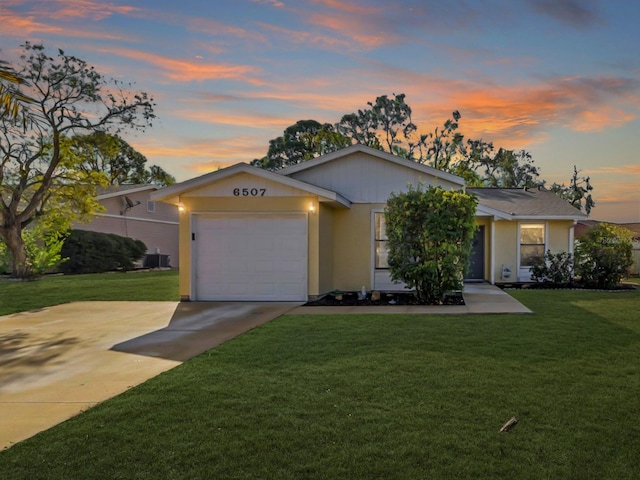 ranch-style house with a garage and a lawn