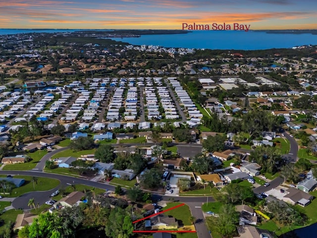 aerial view at dusk featuring a water view