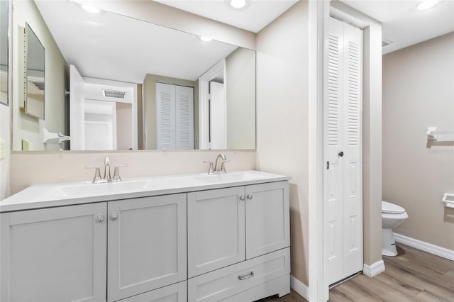 bathroom with hardwood / wood-style flooring, vanity, and toilet