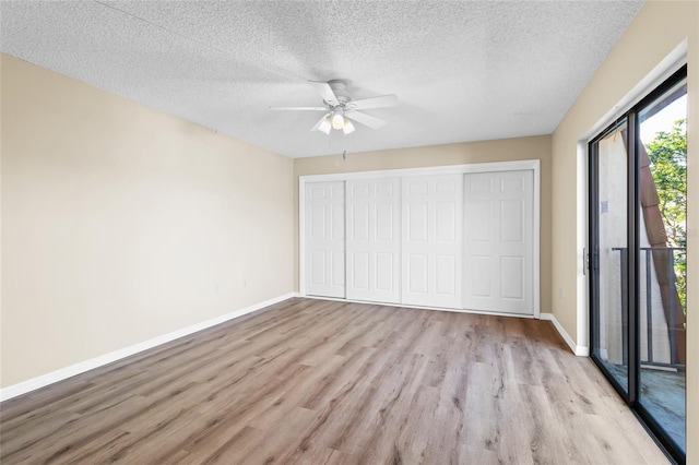 unfurnished bedroom with a textured ceiling, light hardwood / wood-style flooring, a closet, and ceiling fan