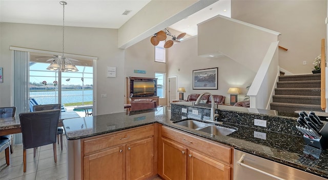 kitchen with pendant lighting, sink, dishwasher, dark stone counters, and a chandelier