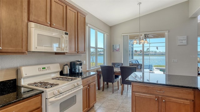 kitchen featuring lofted ceiling, a water view, a chandelier, dark stone countertops, and white appliances