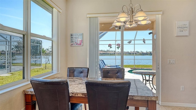 dining room with a water view and a notable chandelier