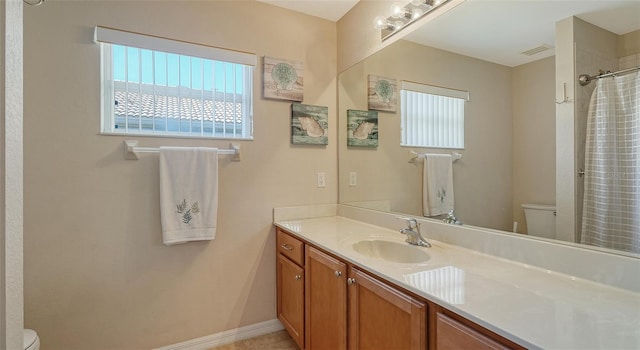 full bath with baseboards, visible vents, vanity, and toilet