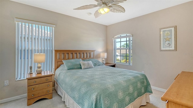 bedroom with light carpet, a ceiling fan, and baseboards