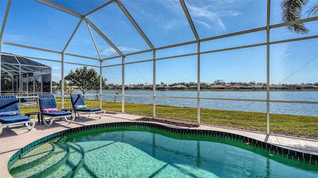 view of pool featuring a water view, a patio area, and glass enclosure